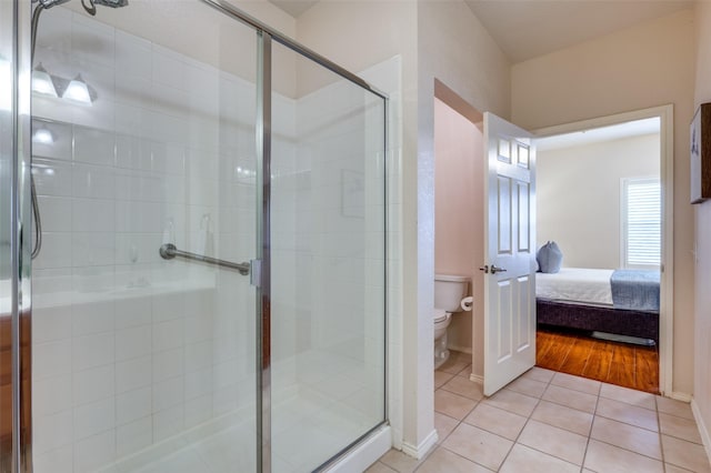 bathroom featuring an enclosed shower, tile patterned floors, and toilet