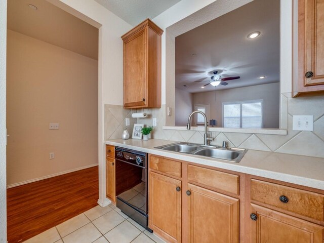 kitchen featuring tasteful backsplash, dishwasher, sink, light tile patterned floors, and ceiling fan