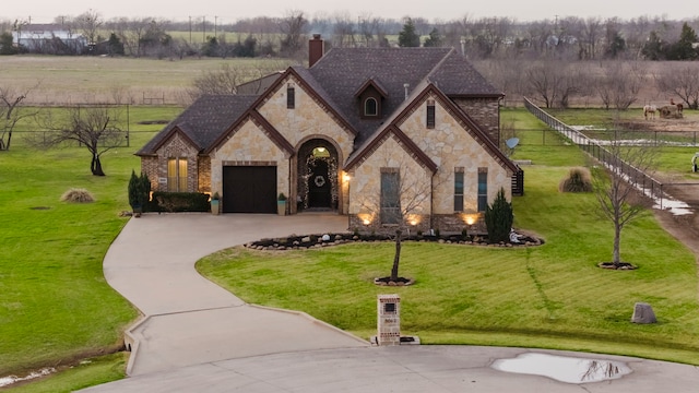 french country home with driveway, a front lawn, a rural view, and fence