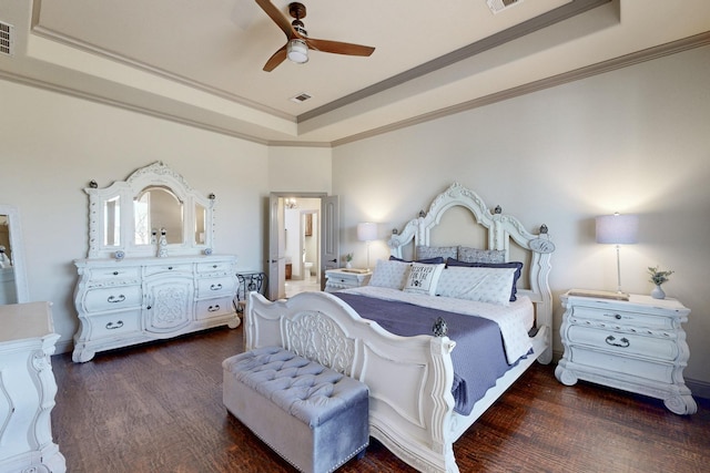 bedroom featuring a raised ceiling, wood finished floors, visible vents, and crown molding