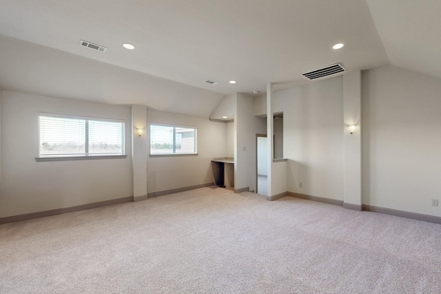 unfurnished room with recessed lighting, light colored carpet, visible vents, baseboards, and vaulted ceiling