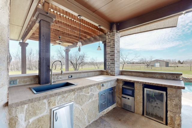 view of patio / terrace with ceiling fan, an outdoor kitchen, a sink, and a pergola