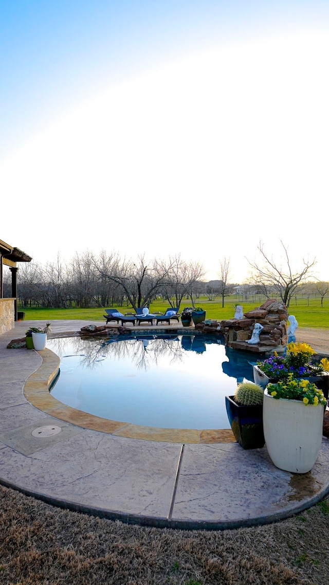 view of swimming pool with a lawn