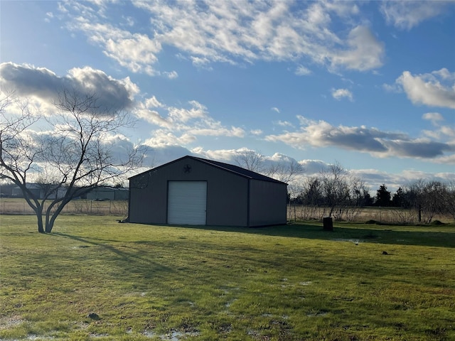 view of pole building with a rural view, a yard, and fence