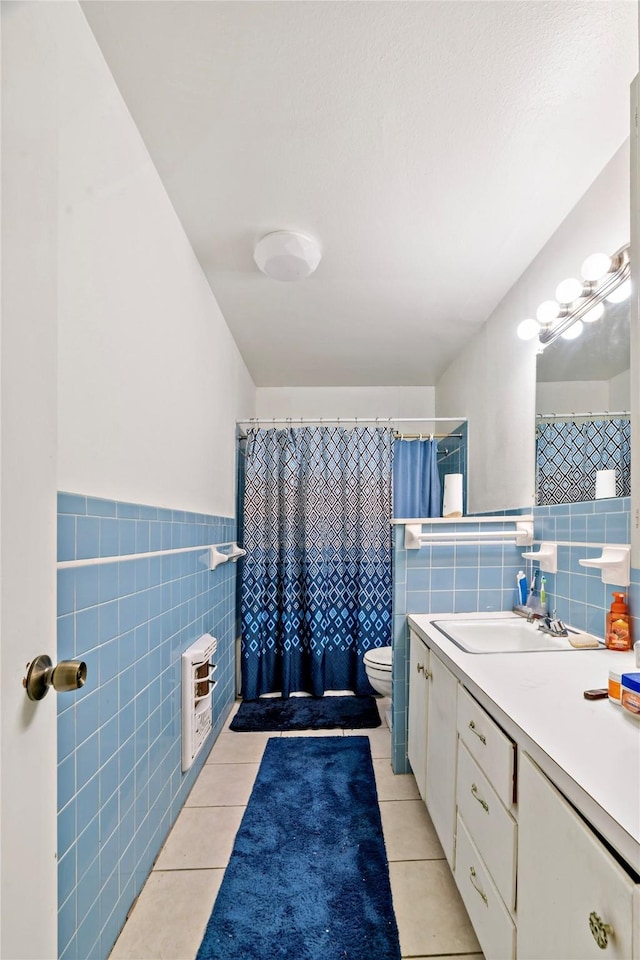 bathroom featuring tile patterned floors, toilet, tile walls, and vanity