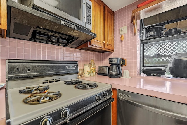 kitchen with appliances with stainless steel finishes and decorative backsplash