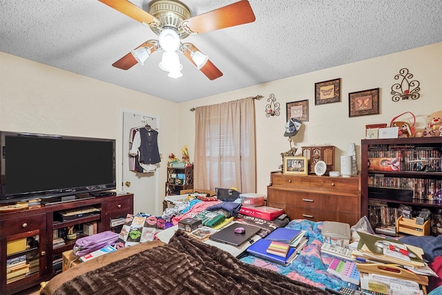 bedroom with ceiling fan and a textured ceiling