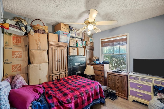 bedroom featuring ceiling fan, a textured ceiling, and light wood-type flooring