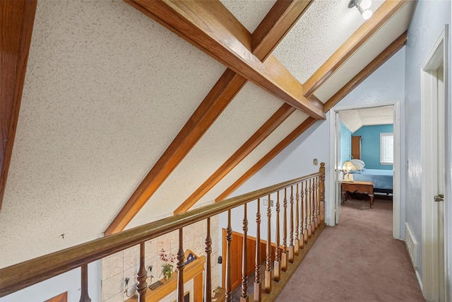 corridor with lofted ceiling with beams and carpet