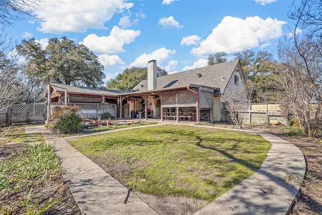 rear view of house with a lawn and a patio area