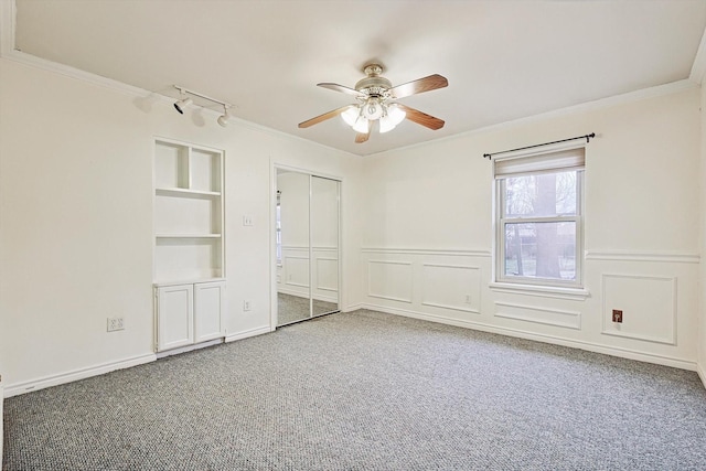 unfurnished bedroom with crown molding, ceiling fan, carpet flooring, and a closet