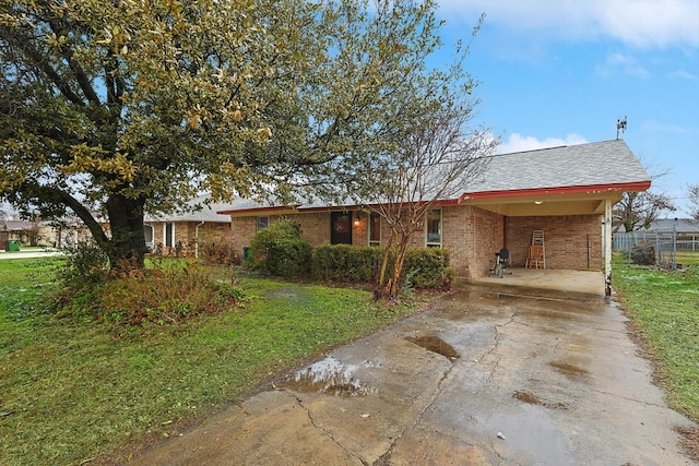 ranch-style home featuring a carport and a front lawn