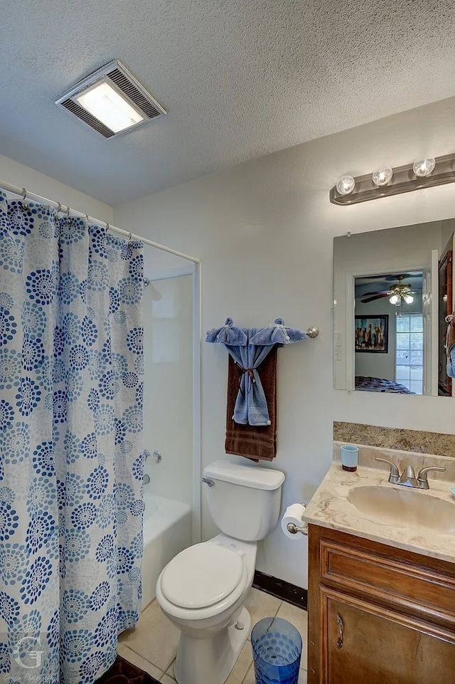 full bathroom featuring tile patterned floors, toilet, vanity, and a textured ceiling