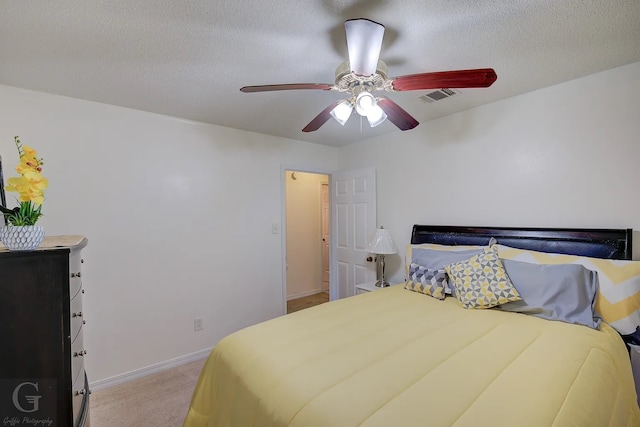 bedroom with light carpet, a textured ceiling, and ceiling fan