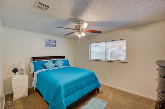 carpeted bedroom featuring a textured ceiling and ceiling fan