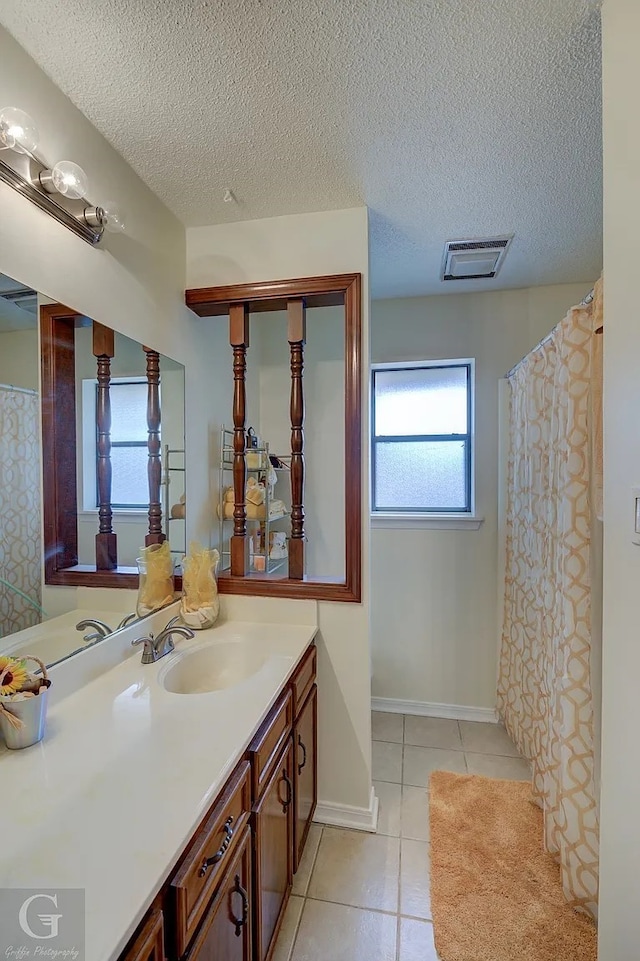 bathroom featuring tile patterned flooring, vanity, and a textured ceiling