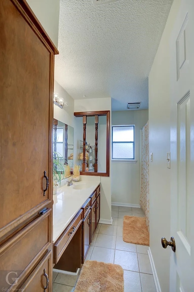 bathroom featuring vanity, tile patterned flooring, and a textured ceiling