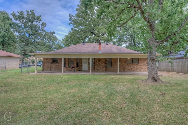 rear view of house featuring a yard and a patio