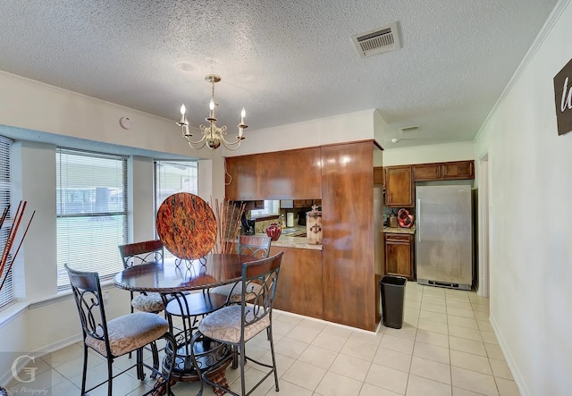 dining area with crown molding, light tile patterned floors, a notable chandelier, and a textured ceiling