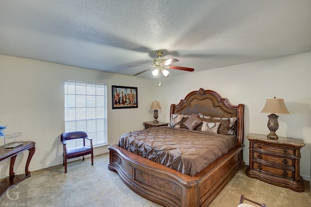 carpeted bedroom with ceiling fan and a textured ceiling