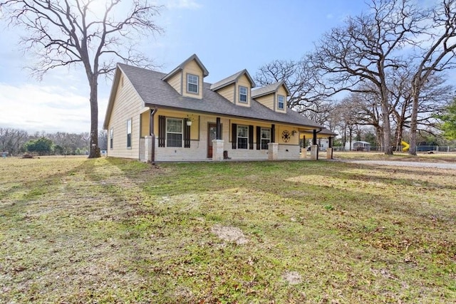 cape cod house with a front yard and a porch