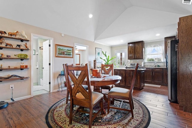 dining area with lofted ceiling and dark wood-type flooring