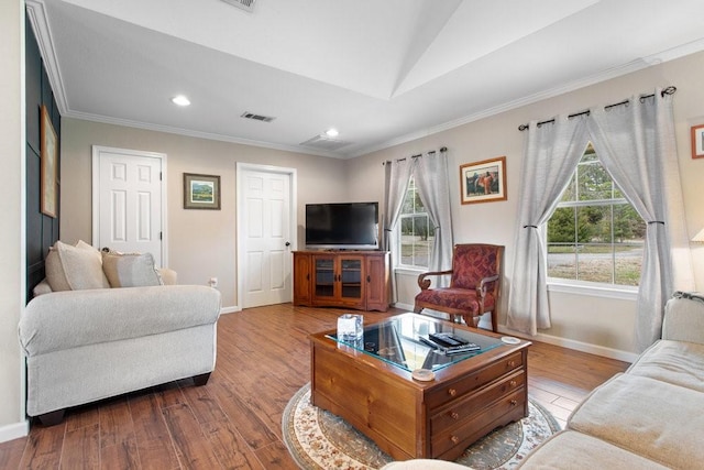 living room featuring vaulted ceiling, ornamental molding, and light wood-type flooring