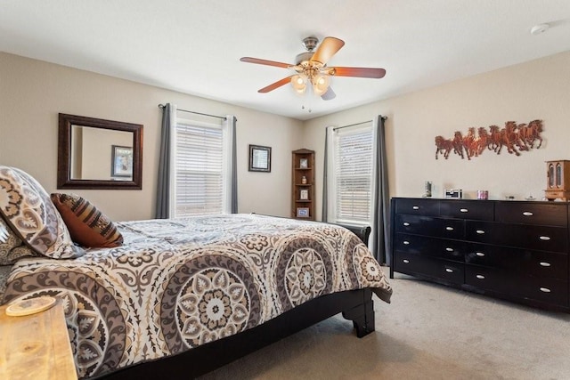 bedroom with ceiling fan and light carpet