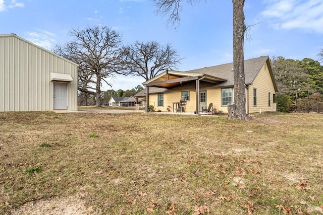 back of house featuring a lawn