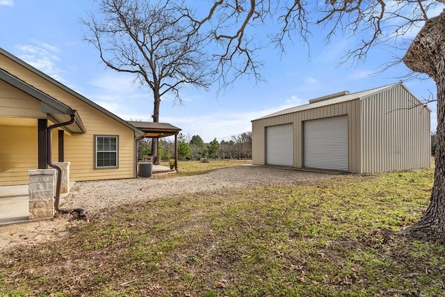 view of yard featuring a garage, an outdoor structure, and central air condition unit