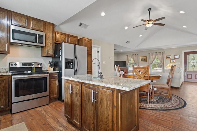 kitchen featuring lofted ceiling, a kitchen island with sink, stainless steel appliances, and dark hardwood / wood-style floors