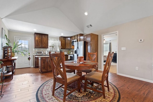 dining room with lofted ceiling, dark wood-type flooring, and ceiling fan