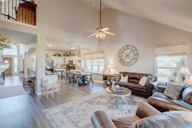 living room featuring ceiling fan, high vaulted ceiling, light hardwood / wood-style floors, and a wealth of natural light