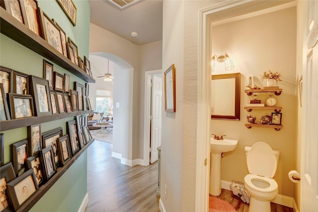 corridor with hardwood / wood-style floors and sink