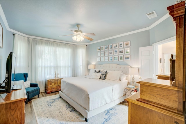 bedroom featuring ornamental molding, ceiling fan, and light hardwood / wood-style flooring