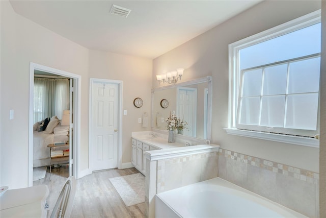 bathroom with vanity, hardwood / wood-style floors, and a tub