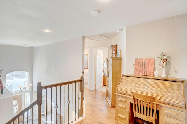 corridor featuring light hardwood / wood-style floors and a chandelier