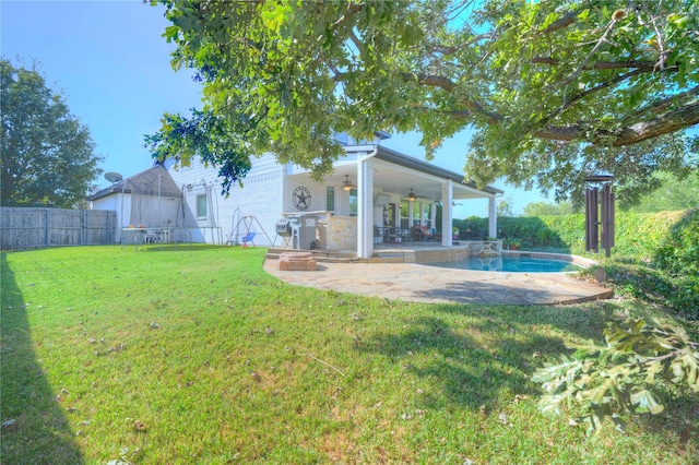 view of yard with ceiling fan, a fenced in pool, and a patio area