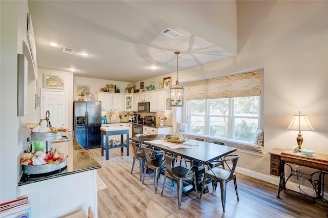 dining room with a notable chandelier and light wood-type flooring