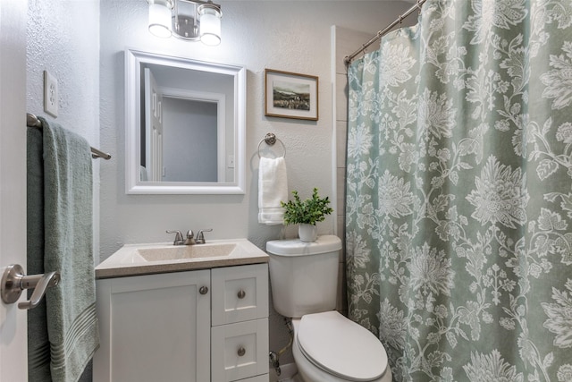 bathroom with vanity, curtained shower, and toilet