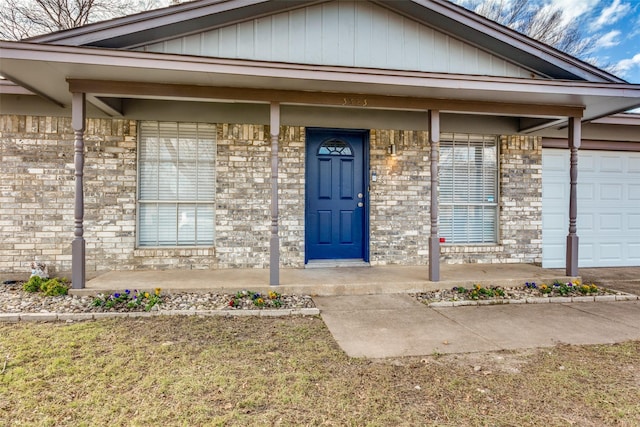 entrance to property featuring a porch and a garage