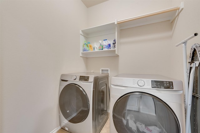 washroom featuring washing machine and dryer and light tile patterned flooring