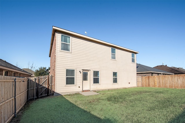 rear view of property featuring a lawn