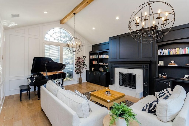 living room with a wealth of natural light, vaulted ceiling with beams, a notable chandelier, a fireplace, and light hardwood / wood-style floors