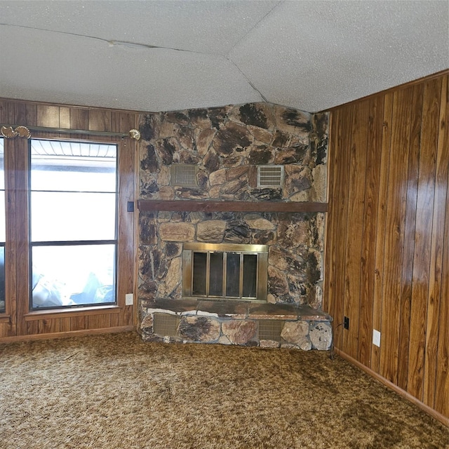 134 Hollie Dr, Red Oak, TX 75154 - unfurnished living room featuring carpet flooring, a fireplace, and wood walls