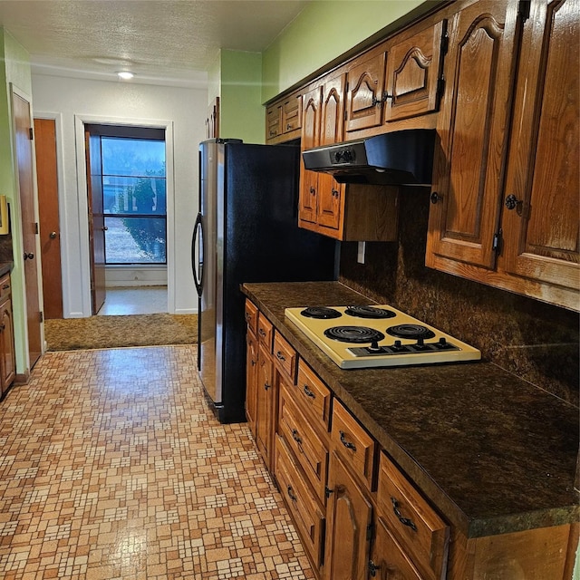 134 Hollie Dr, Red Oak, TX 75154 - kitchen featuring stainless steel refrigerator, tasteful backsplash, extractor fan, white electric cooktop, and a textured ceiling