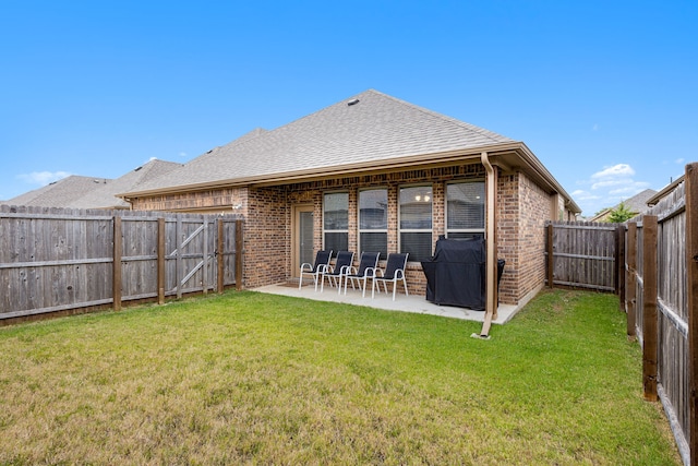 rear view of property with a lawn and a patio