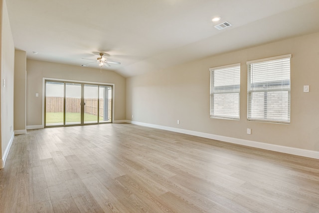 spare room with ceiling fan, vaulted ceiling, and light hardwood / wood-style floors