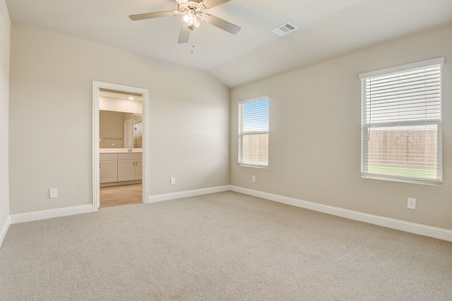 empty room featuring lofted ceiling, light colored carpet, and ceiling fan