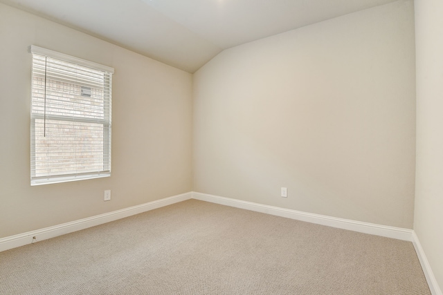 unfurnished room featuring vaulted ceiling and carpet flooring